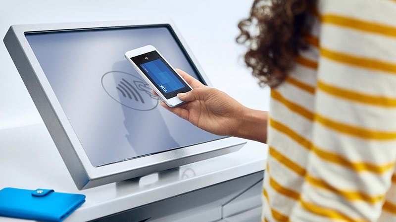 Woman making contactless payment with smart phone.