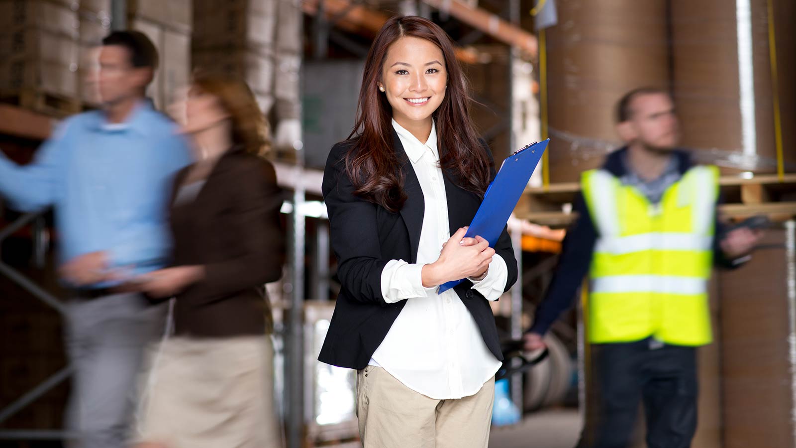 Woman holding a clipboard in a warehouse.