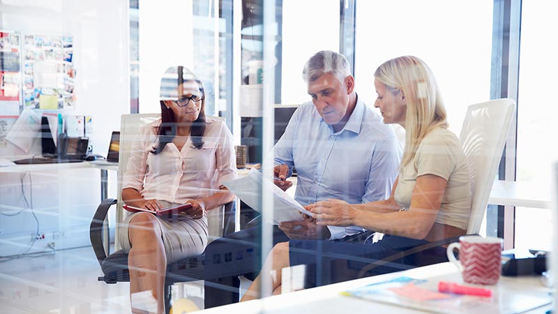 Three people in a office discussion