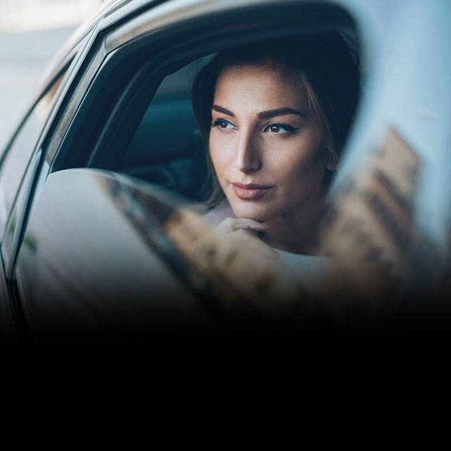 woman looking out the window of a car